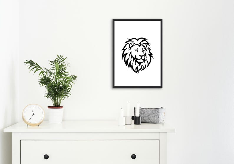 May include: Black and white framed art print featuring a detailed lion's head. The artwork is displayed on a white wall above a white dresser, alongside a potted plant and decorative items.