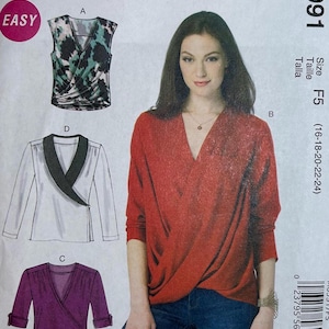 May include: A sewing pattern for a wrap top with long sleeves. The pattern includes three different styles: a sleeveless top with a black and green print, a white top with a black collar, and a purple top with long sleeves. The pattern is for sizes 16-18-20-22-24. The pattern is labelled "M6991 Size F5 (16-18-20-22-24)".