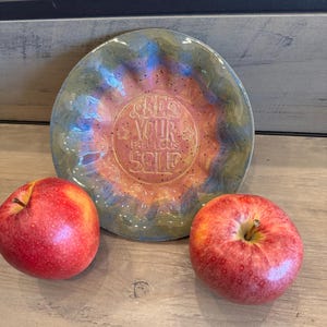 Piatto in ceramica fatto a mano con motivo arricciato, con la scritta "Sii te stesso favoloso" nei toni del rosa, del blu e del verde