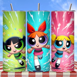 Puede incluir: Tres vasos de acero inoxidable con las Supernenas. Cada vaso tiene un color de fondo diferente: verde, turquesa y rosa. Los personajes de dibujos animados están en el centro de cada vaso, con una pajita en la parte superior.