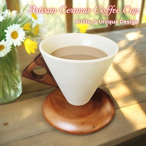 Puede incluir: Taza de café de cerámica blanca con base y asa de madera marrón. La taza está llena de café. El texto de la imagen dice "Artisan Ceramic Coffee Cup Rustic & Unique Design."