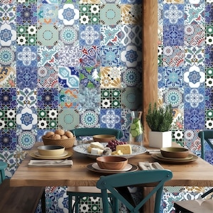 Puede incluir: Una escena de comedor con una mesa de madera con platos, cuencos y comida. El fondo muestra una pared cubierta de azulejos coloridos y estampados en tonos azules, verdes y blancos. También se ve un jarrón con una planta y una jarra de agua.