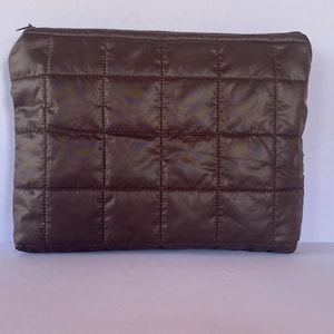 Könnte beinhalten: Ein Set aus drei Keramikbechern mit gesprenkelter, matter Oberfläche. Die Becher sind in Creme-, Hellgrau- und Dunkelgrautönen gehalten. Jeder Becher hat ein schlichtes, minimalistisches Design.