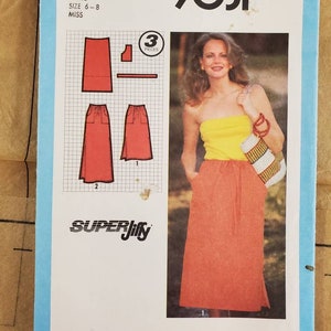 May include: Simplicity sewing pattern number 9031 for a petite size 6-8 skirt. The pattern includes three pieces and is labeled "Super Jiffy". The image shows a model wearing a red skirt with a yellow top.