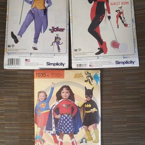 May include: Three Simplicity sewing pattern envelopes featuring DC Comics characters. The patterns include The Joker, Harley Quinn, and Wonder Woman, Supergirl, and Batgirl costumes. The Joker pattern shows a purple suit, and Harley Quinn is in a red and black outfit.