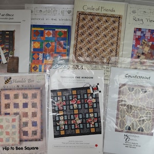 May include: A collection of quilting patterns featuring various designs, including "Circle of Friends", "Rag Time Quilt", "Diamond in the Window", "All at Once", "Through the Window", "Humble Bee Quilt Works", and "Counterpoint".