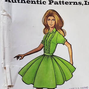 May include: A vintage sewing pattern featuring a woman wearing a green dress with a ruffled collar and short sleeves. The pattern is titled "Authentic Patterns, Inc."