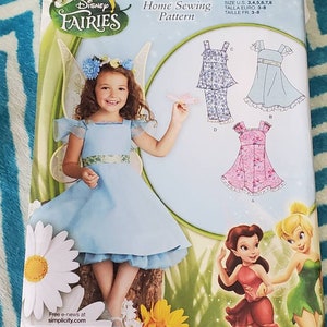 May include: A sewing pattern for a Disney Fairies dress. The pattern includes instructions for making a blue dress with a white lace trim, a pink dress with a white lace trim, and a blue and white dress with a white lace trim. The pattern is for sizes 3-8.