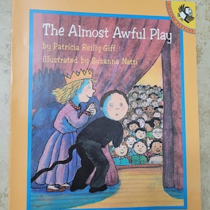 May include: A children's book cover with a yellow background and a blue border. The title is "The Almost Awful Play" by Patricia Reilly Giff, illustrated by Susanna Natti. The cover features an illustration of two children on a stage with a curtain behind them. The child on the left is wearing a crown and a purple dress. The child on the right is wearing a black costume with a tail. There are many children in the audience.