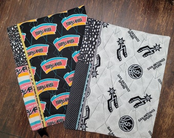 May include: Three fabric squares with a black and white polka dot pattern, a black and white geometric pattern, and a white background with black San Antonio Spurs logos.