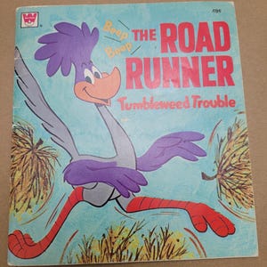 May include: Vintage Road Runner book cover featuring the cartoon character in motion. The cover is light blue with the title "The Road Runner" in red, and the text "Tumbleweed Trouble". The Road Runner is depicted in purple, gray, and red.