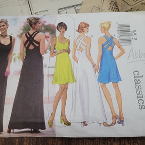 May include: A sewing pattern for four different dresses. The dresses are sleeveless and have a criss-cross back design. The pattern is from Butterick and is number 5542. The pattern is called Abby Classics.