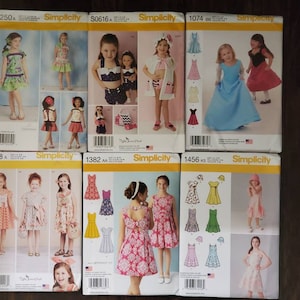May include: Eight different Simplicity sewing patterns for children's clothing. The patterns feature a variety of styles, including dresses, skirts, and tops. The patterns are all in the same style, with a white background and a yellow border. The patterns are all for different sizes, ranging from 2-14.