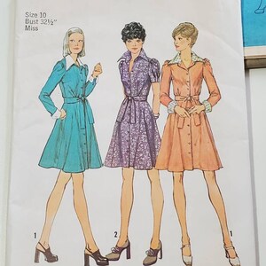 May include: Simplicity sewing pattern number 6554 for a dress. The pattern includes instructions for three different styles of dresses: a teal dress with a white collar, a purple floral dress with a white collar, and a peach dress with a white collar. The pattern is for size 10, bust 32 1/2 inches.