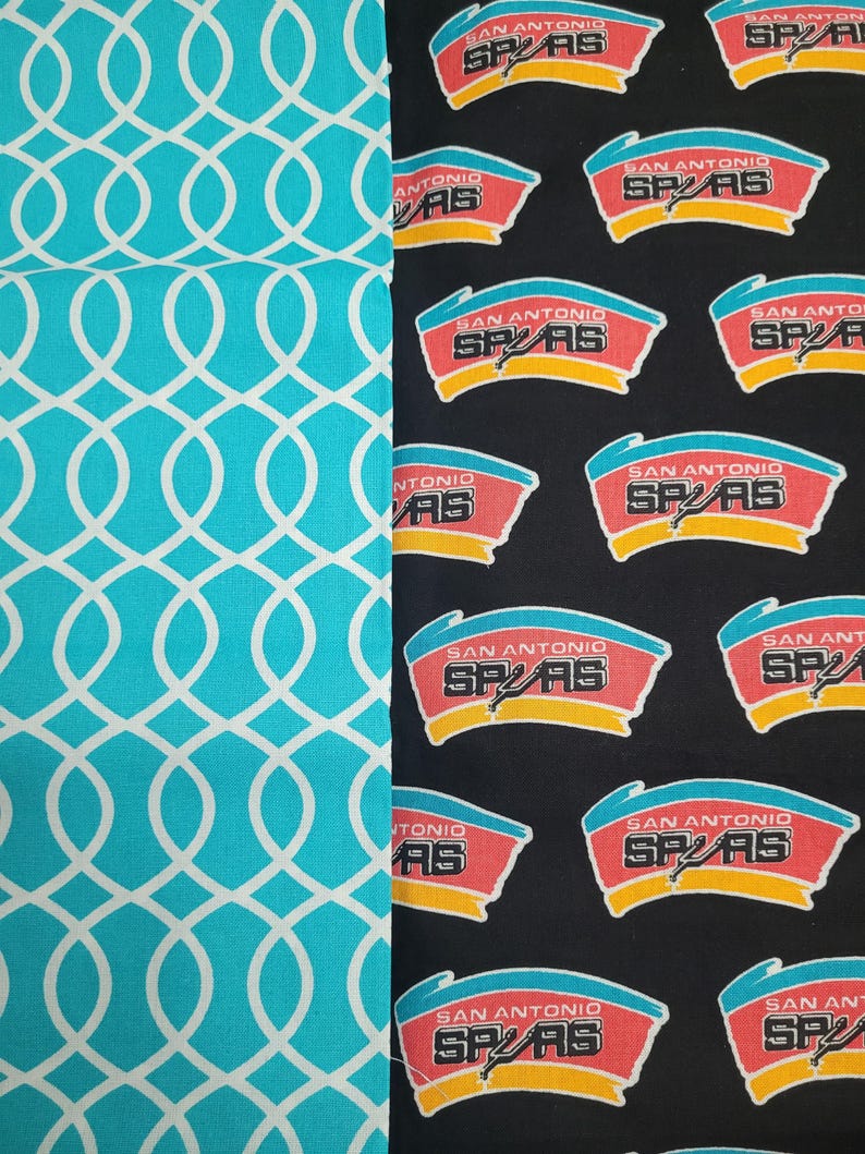 May include: Two fabric patterns are displayed. One features a teal background with a white interlocking oval design. The other is black with a repeating logo of the San Antonio Spurs basketball team in red, white, and yellow.