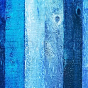 May include: A close-up of a wooden surface with vertical planks in varying shades of blue. The planks have visible wood grain and knots, creating a textured and rustic appearance. The color palette ranges from deep navy to light sky blue.
