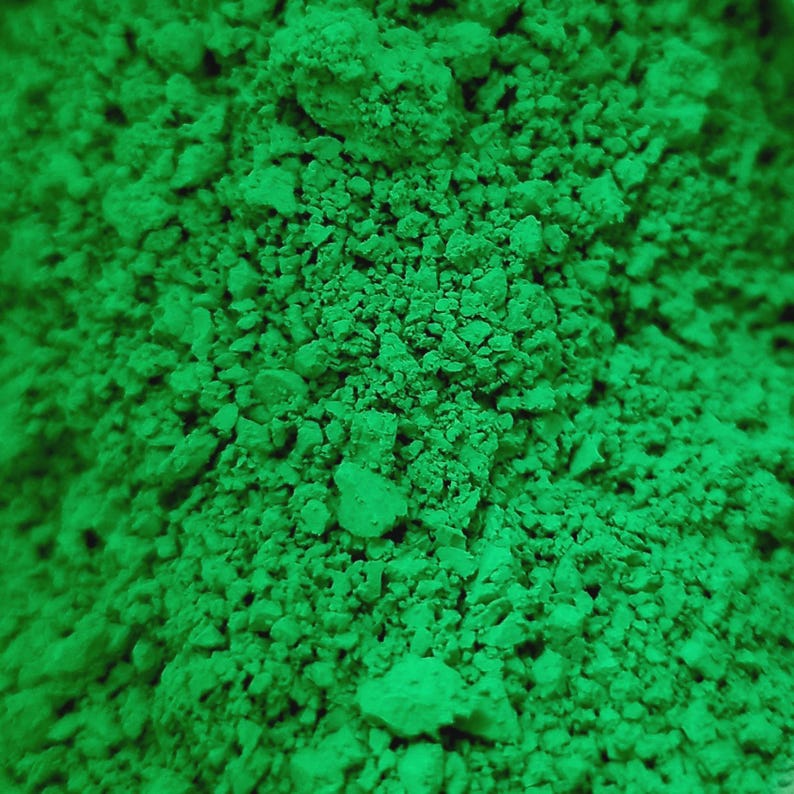 Puede incluir: Primer plano de un mont&oacute;n de polvo verde brillante con una apariencia texturizada y granular. El polvo est&aacute; finamente molido, con peque&ntilde;os grumos y variaciones en la textura. El color es un verde vibrante y saturado.