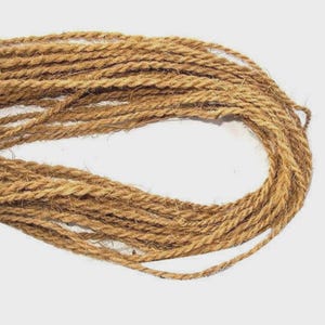 May include: A coil of natural brown rope. The rope is made from tightly twisted fibres, creating a textured surface. The rope appears to be of medium thickness and is suitable for various crafting and decorative purposes.