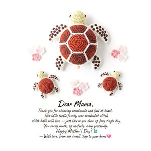 Puede incluir: Familia de tortugas de ganchillo en tonos marrón, crema y blanco, con detalles de flores rosas y blancas. Las tortugas tienen patrones de caparazón detallados y están dispuestas sobre un fondo blanco. Texto: "Dear Mama, Happy Mother's Day!"