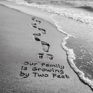 Puede incluir: Fotografía en blanco y negro de huellas en la arena que conducen al océano. El texto en la arena dice: "Our Family is Growing by Two Feet."