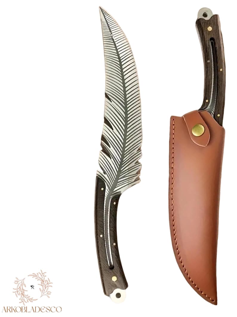 May include: A handcrafted knife with a feather-shaped blade and a dark wooden handle. The blade is silver with etched feather details. It includes a brown leather sheath with a brass button closure. The knife is approximately 25 cm long.