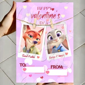 May include: A pink Valentine's Day card with cartoon characters Nick Wilde and Judy Hopps from Zootropolis. The card has hearts and the words "Happy Valentine's Day." The photos are held by wooden pegs.