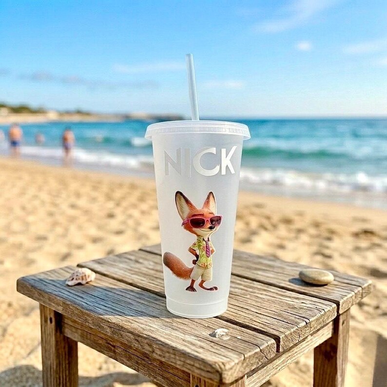 May include: A frosted plastic tumbler with a lid and straw, featuring the name NICK in white capital letters above a colorful graphic of a cartoon fox wearing pink sunglasses, a light green patterned shirt, and tan shorts.