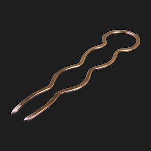 May include: A bronze-colored hair pin with a wavy design. The pin has a loop at the top and two prongs at the bottom. The hair accessory is made of metal and is set against a black background.