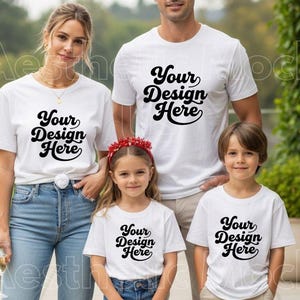 Può includere: Una famiglia di quattro persone indossa magliette bianche abbinate con la scritta "Your Design Here" in nero. La famiglia è in piedi all'aperto con vegetazione sullo sfondo.