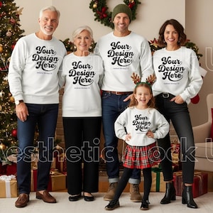 Puede incluir: Una familia de cinco personas con sudaderas blancas a juego con el texto "Your Design Here" en negro. La familia posa frente a un árbol de Navidad y una chimenea. La niña lleva una falda escocesa roja.