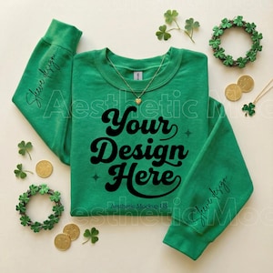 Könnte beinhalten: Ein grünes Sweatshirt mit dem Text "Your Design Here" in einer Retro-Schriftart. Die Ärmel tragen den Text "Sleeve design". Das Bild enthält Goldmünzen, Kleeblätter und eine Halskette mit einem Herzanhänger und einem Kleeblattanhänger.