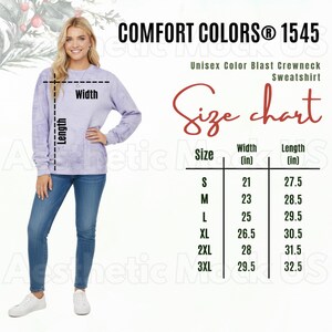 Może przedstawiać: Kobieta w lawendowej bluzie z okrągłym dekoltem i niebieskich dżinsach. Bluza ma napis "COMFORT COLORS® 1545" oraz tabelę rozmiarów z wymiarami w calach. Tabela rozmiarów zawiera rozmiary od S do 3XL.