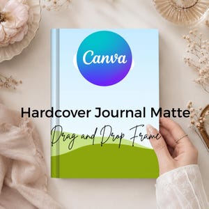 May include: A hardcover journal with a matte finish featuring a light blue sky and green hills graphic. The cover displays the text Canva in a purple circle, along with the words Hardcover Journal Matte and Drag and Drop Frame in black text.