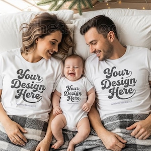 Può includere: Una famiglia di tre persone indossa magliette bianche abbinate e un body con la scritta "Your Design Here". I genitori e il bambino sono sdraiati su un letto, sorridenti. È visibile anche il testo "Aesthetic Mockup US".