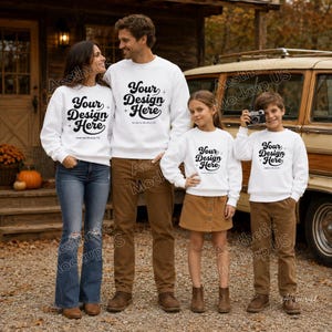 May include: A family of four wearing matching white crewneck sweatshirts with the black text Your Design Here printed on the front. The group consists of two adults and two children, all styled in casual clothing including blue jeans and brown trousers.