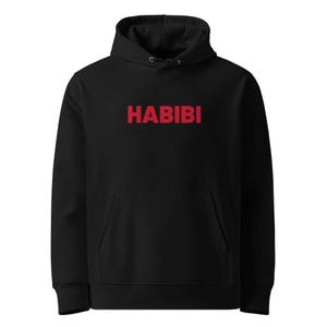 Peut inclure: Sweat à capuche noir avec une poche avant et le mot "HABIBI" imprimé en rouge sur la poitrine. Le sweat à capuche a une capuche à cordon et des manches longues. Un vêtement décontracté et confortable.