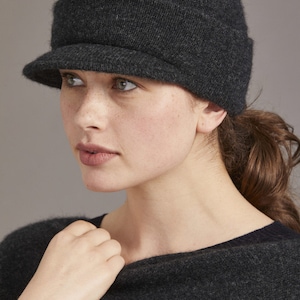 May include: A dark gray knitted beanie with a wide brim. The beanie has a slouchy fit and is made of a soft, comfortable material.