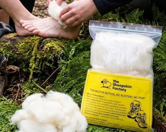 May include: A clear plastic bag containing white New Zealand wool, labeled The Sheepskin Factory with the text The Blister Blitzer, No Blisters, No Pain. A loose pile of the same white wool sits next to the bag, which features a graphic of hiking boots.