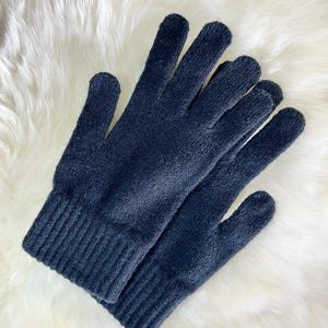 May include: A pair of black knitted gloves with a ribbed cuff. The gloves are made from a soft, warm material and are ideal for keeping your hands warm in cold weather.