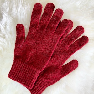 May include: A pair of red knitted gloves with a ribbed cuff. The gloves are made of a soft, warm material and are perfect for keeping your hands warm in cold weather.
