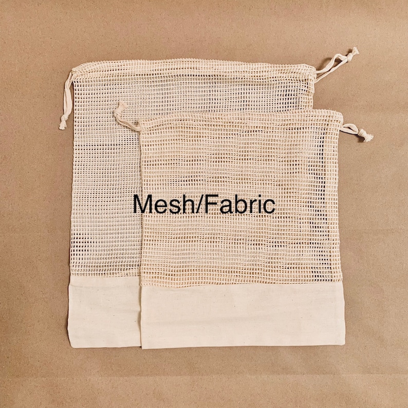May include: Two beige mesh produce bags with white fabric bottoms and drawstring closures. The bags are stacked on top of each other. The text "Mesh/Fabric" is printed on the bags.