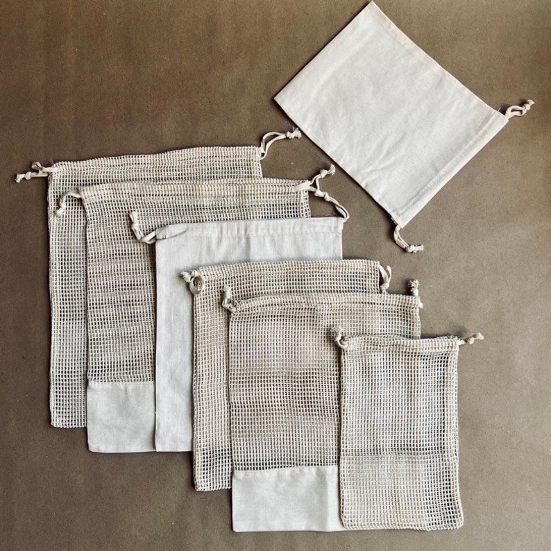 May include: Set of eight reusable produce bags. The bags are made of a white mesh material and have a drawstring closure. There are also two solid white fabric bags with a drawstring closure.