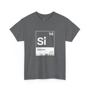 May include: Dark grey t-shirt displaying a white graphic of the periodic table element Silicon, labelled "Si" with atomic number 14. The shirt is made of a soft material and has a classic crew neck design.