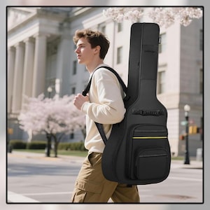 May include: Black guitar case with a yellow accent stripe and a front pocket. The case is being carried over the shoulder. The person is walking on a city street with a building and trees in the background.