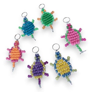 May include: Six beaded turtle keychains in various colors, including blue, green, orange, pink, yellow, and purple. Each turtle has a silver-colored metal keyring attached. The turtles are made of small, colorful beads.