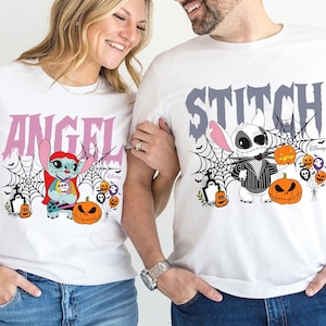Pode incluir: T-shirts brancas com gr&aacute;ficos de Stitch e Angel com tema de Halloween. Uma camisa apresenta "ANGEL" em rosa, a outra "STITCH" em cinza. Ambas apresentam teias de aranha, ab&oacute;boras e a marca Disney.