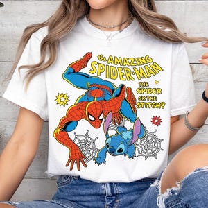 May include: White t-shirt featuring a colorful graphic of Spider-Man and Stitch. The design includes the text "THE AMAZING SPIDER-MAN" and "THE SPIDER OR THE STITCH?" The illustration is in a comic book style with vibrant colors and web details.