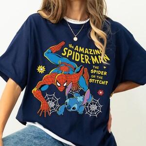 May include: Navy blue t-shirt featuring a graphic of Spider-Man and Stitch with the text "The Amazing Spider-Man, The Spider or the Stitch?". The design includes spiderwebs, stars, and a heart.
