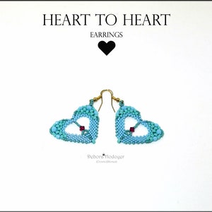 May include: Heart-shaped earrings with a beaded design in shades of turquoise and teal, featuring a small red accent in the center. The earrings hang from gold-colored hooks. The text "HEART TO HEART EARRINGS" is at the top.