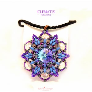 May include: A handcrafted pendant with a floral design, incorporating a central iridescent crystal. The pendant's colour scheme is predominantly blue and purple, with white and dark bead accents. The text "CLEMATIS" and "PENDANT" are visible.
